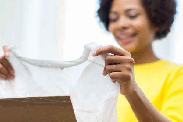 Gelukkig Afrikaanse jonge vrouw met perceel vak thuis — Stockfoto