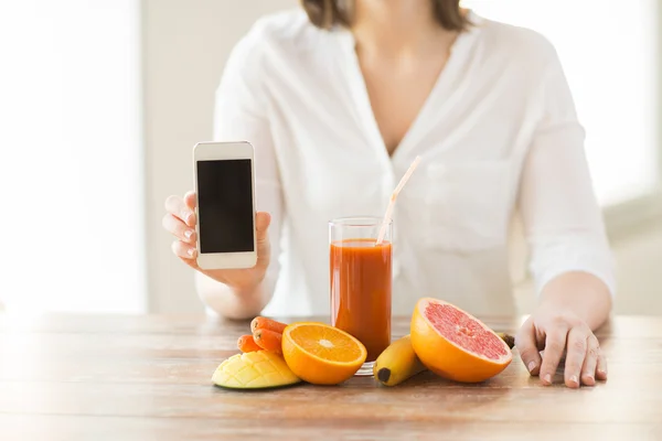 Primer plano de las manos de la mujer con frutas de teléfonos inteligentes — Foto de Stock