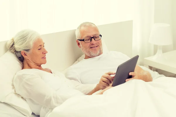 Happy senior couple with tablet pc at home — Stock Photo, Image