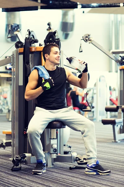 Hombre sonriente haciendo ejercicio en la máquina de gimnasio — Foto de Stock