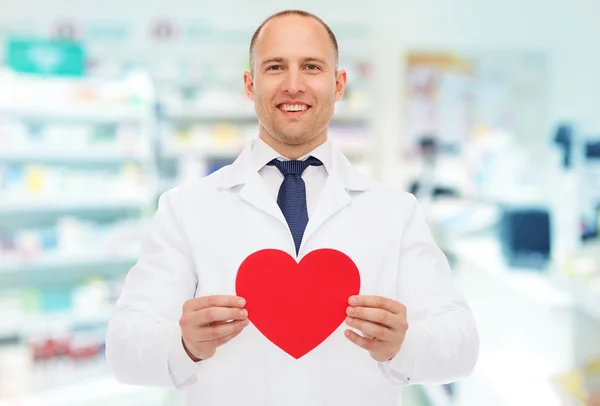 Male pharmacist with heart at drugstore — Stock Photo, Image