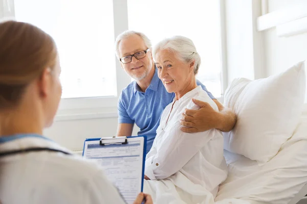 Femme âgée et médecin avec presse-papiers à l'hôpital — Photo