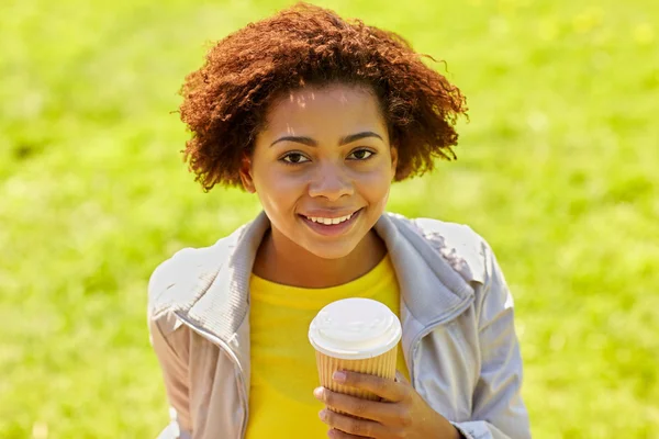 Smiling african woman drinking coffee outdoors — Stock Photo, Image