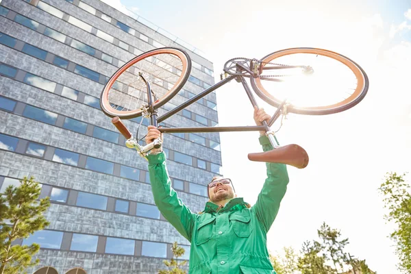 young hipster man rising fixed gear bike in city