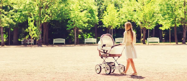 Happy mother with stroller in park — Stock Photo, Image