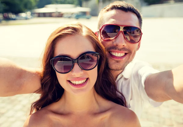 Leende par bär solglasögon att göra selfie — Stockfoto