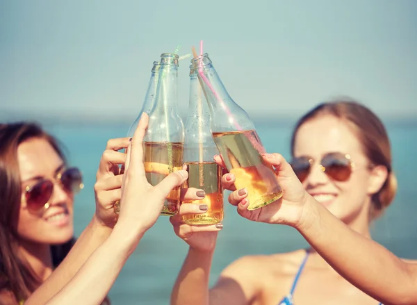 Primer plano de las mujeres jóvenes felices con bebidas en la playa —  Fotos de Stock