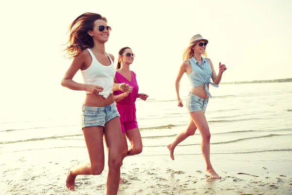 Groupe de femmes souriantes courant sur la plage — Photo