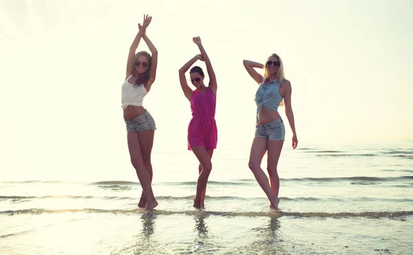 Happy female friends dancing on beach — Stock Photo, Image