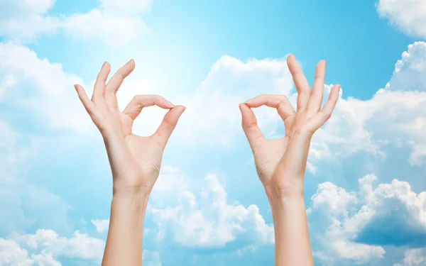 Woman hands showing ok sign over blue sky — Stockfoto