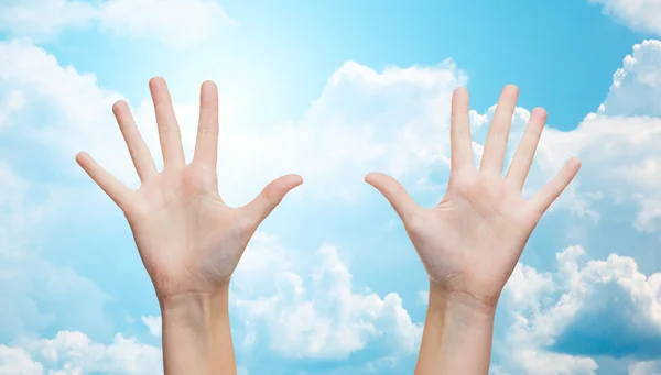 Two woman hands making high five over blue sky — Stock fotografie