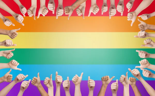 Mãos mostrando polegares para cima em círculo sobre arco-íris — Fotografia de Stock