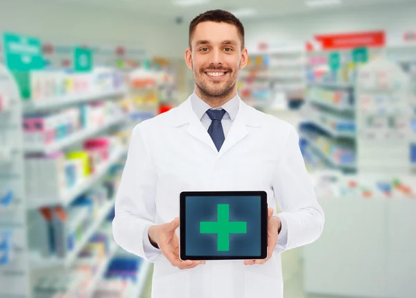 Doctor masculino sonriente con la PC tableta en la farmacia — Foto de Stock