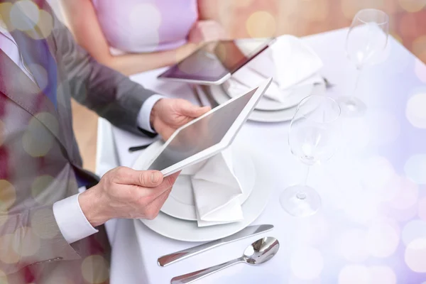 Primer plano de pareja con tablet pc en el restaurante — Foto de Stock