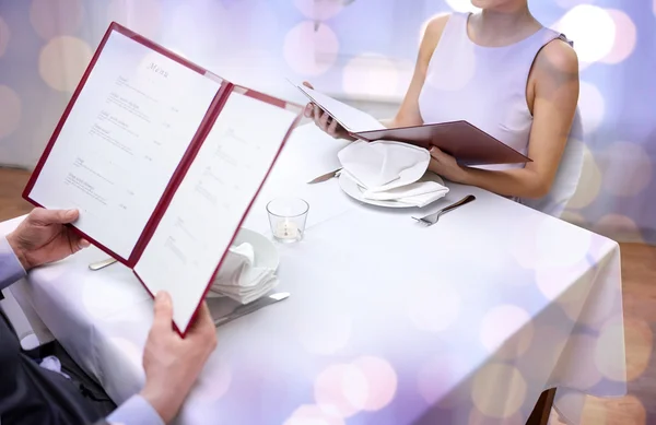 Close up of couple with menu at restaurant — Stock Photo, Image