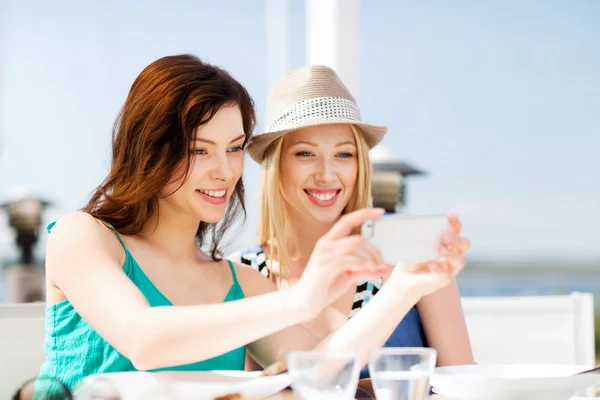 Chicas tomando fotos en la cafetería en la playa —  Fotos de Stock