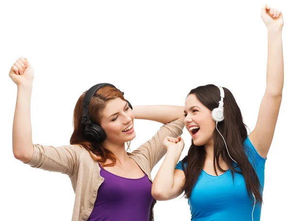 Duas garotas rindo com fones de ouvido dançando — Fotografia de Stock