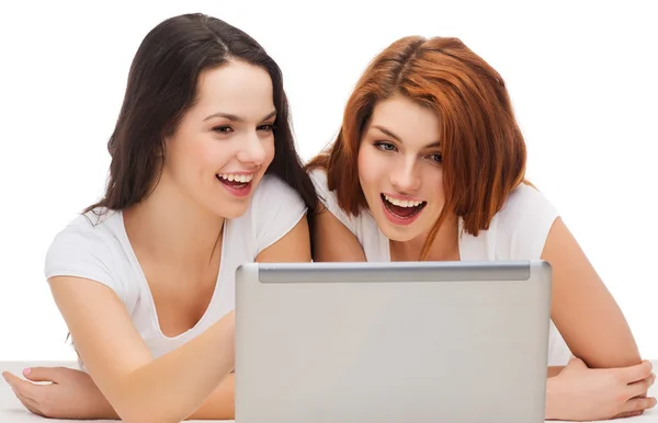 Dva usmívající se dospívající girsl s přenosným počítačem — Stock fotografie