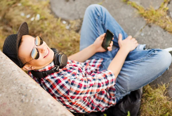 Meisje met hoofdtelefoon en smartphone — Stockfoto