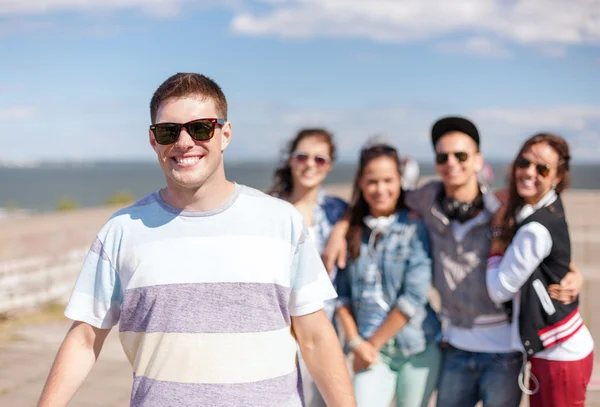 Tonårspojke med solglasögon och vänner utanför — Stockfoto