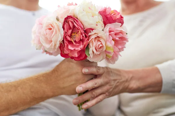 Close up of senior couple with flowers — Stock Photo, Image