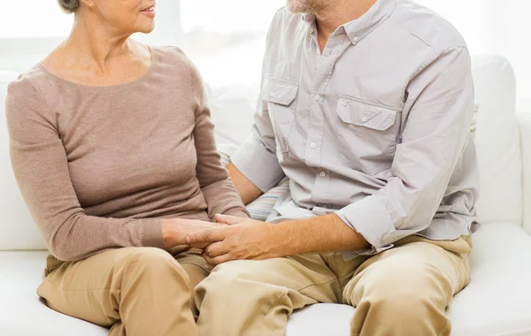 Close up of senior couple holding hands at home — Stock Photo, Image