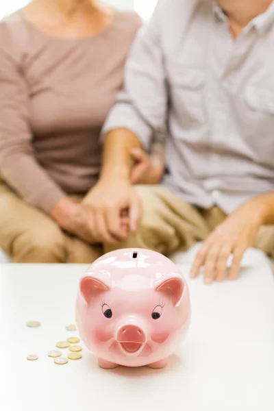 Close up of couple with coins and piggy bank — Stock Photo, Image