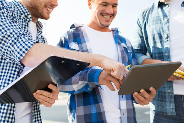 Gruppo di costruttori sorridenti con tablet pc all'aperto — Foto Stock