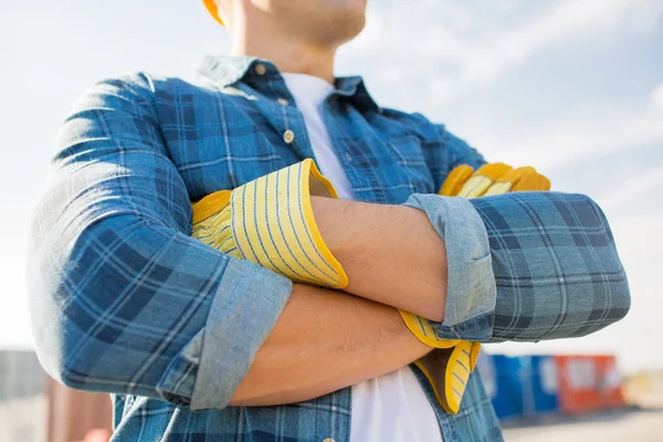 Close up of builder crossed hands in gloves — Stock Photo, Image