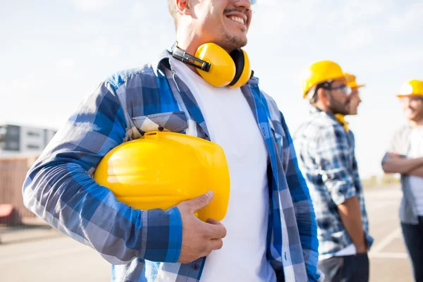 Gros plan du constructeur tenant le casque de sécurité au bâtiment — Photo