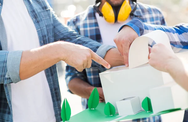 Close-up de construtores com modelo de casa de papel — Fotografia de Stock