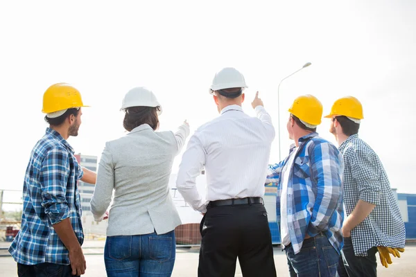 Grupo de construtores e arquitetos no canteiro de obras — Fotografia de Stock