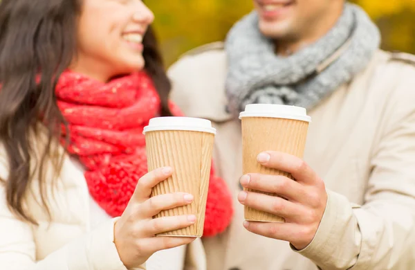 Smiling couple with coffee cups in autumn park — Stock Photo, Image