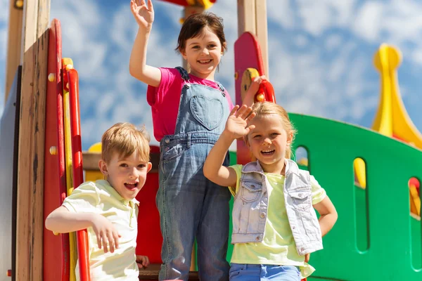 Група щасливих дітей махають руками на дитячому майданчику — стокове фото