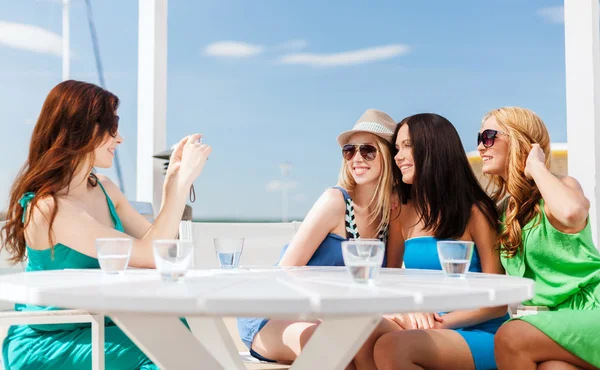 Chicas tomando fotos en la cafetería en la playa Imagen De Stock