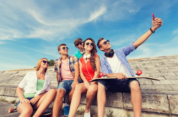 Grupo de amigos sonrientes con teléfono inteligente al aire libre —  Fotos de Stock