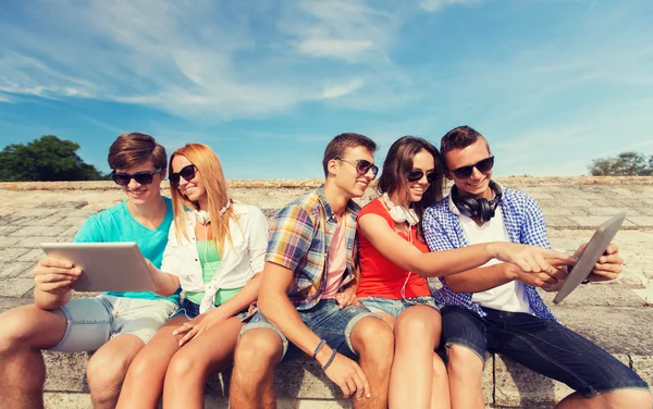 Grupo de amigos sonrientes con tableta PC al aire libre —  Fotos de Stock