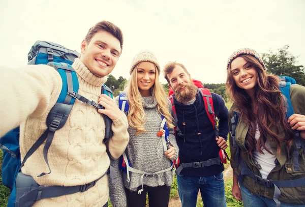 Gruppe lächelnder Freunde mit Rucksäcken beim Wandern — Stockfoto