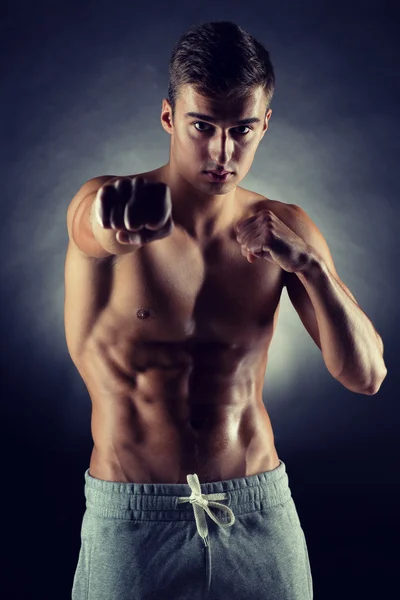 Young man on fighting stand over black background — Stock Photo, Image