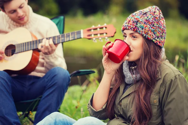 Leende par med gitarr i camping — Stockfoto