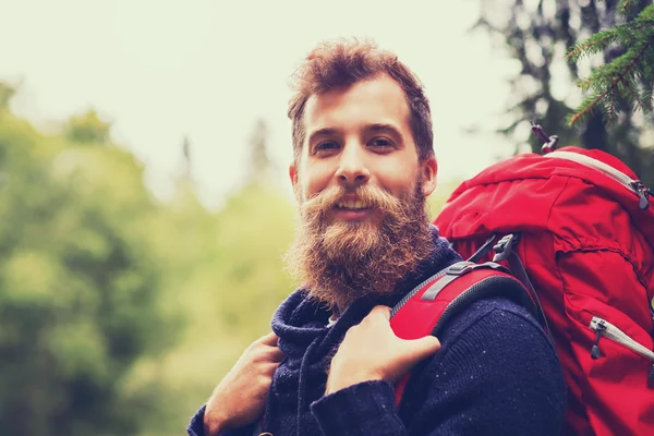 Homem sorridente com barba e mochila caminhadas — Fotografia de Stock