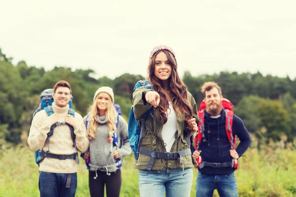 Smiling hikers with backpacks pointing finger — Stock Photo, Image