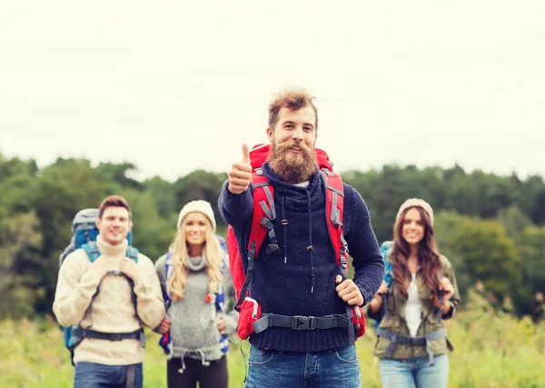 Group of smiling friends with backpacks hiking — Stock Photo, Image