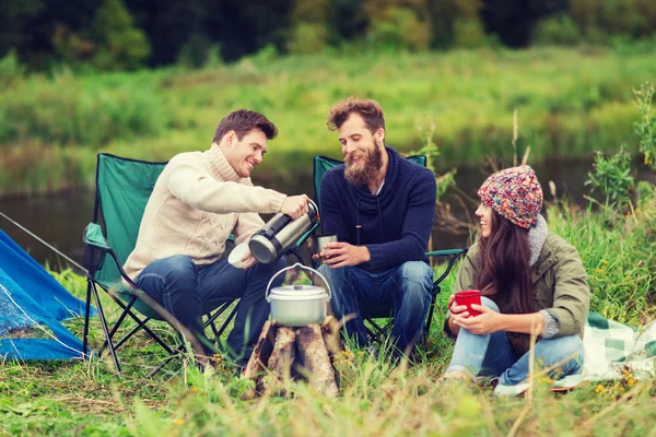 Groupe de touristes souriants cuisiner des aliments dans le camping — Photo