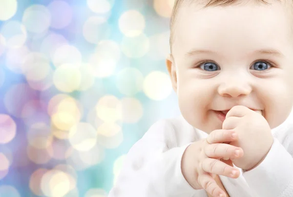 Bebê feliz sobre azul feriados luzes fundo — Fotografia de Stock