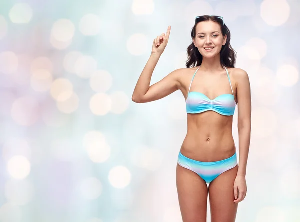 Femme heureuse en maillot de bain bikini pointant le doigt vers le haut — Photo