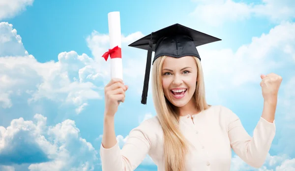 Estudante em gorro trincheira com diploma sobre o céu azul — Fotografia de Stock