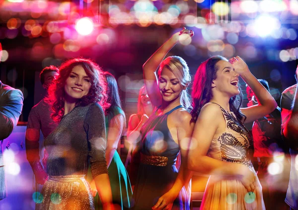 Happy friends dancing in club with holidays lights — Stock Photo, Image