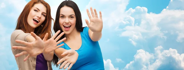 Happy girls or young women showing their palms — Stok fotoğraf