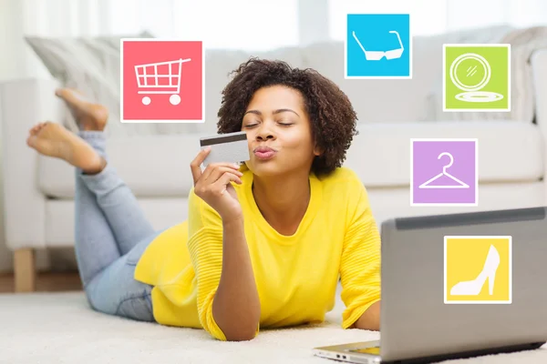 Mujer africana feliz con ordenador portátil y tarjeta de crédito —  Fotos de Stock